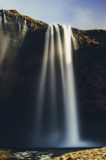A majestic Seljalandsfoss waterfall cascades from tall cliffs in Iceland, its mist creating a