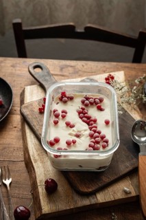 Top view of rich and creamy homemade ice cream garnished with red currants and gooseberries in a