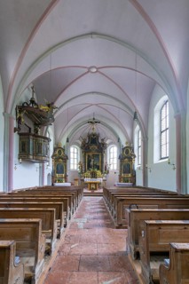 Parish church of St. Sebastian, interior with wooden benches and a central altar, high Gothic