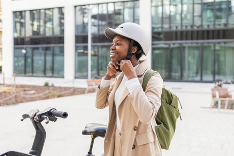 A black woman enjoys a moment outdoors, ready to cycle through the urban landscape She wears a