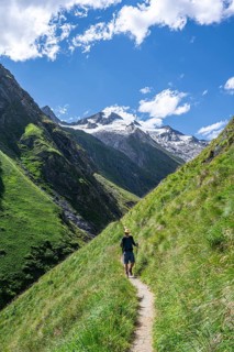 Mountaineers on a hiking trail in Umbaltal, glaciated mountain peaks in the background, Venediger