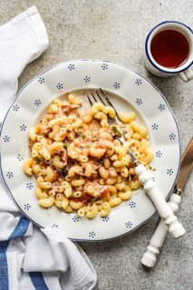 A delicious serving of chifferi rigati pasta, topped with savory tomato sauce and fresh herbs,