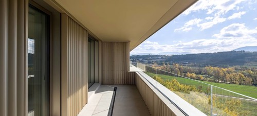 A modern balcony with a sweeping view of lush landscapes, emphasizing sustainable architecture