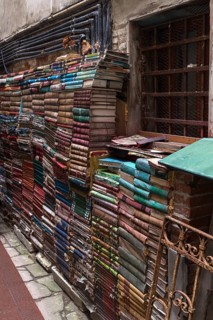 Stacked books on a wall after flood damage in a bookstore, Venice, Veneto, Italy