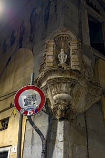 Madonna figure in a niche with decorative frame on a corner house in the historic centre, Genoa,