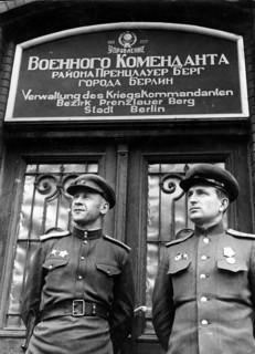 Two Soviet soldiers in front of the administration of the war commander for the district of