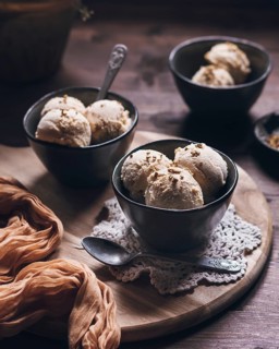 Three bowls of creamy peanut butter ice cream made with Greek yogurt and cream, presented in a