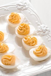 Boiled eggs stuffed with yolk with mayonnaise, on a white plate, selective focus, blurry, close-up,