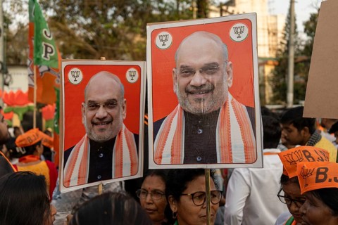 Supporters hold placards featuring Amit Shah during a public rally of the Bharatiya Janata Party