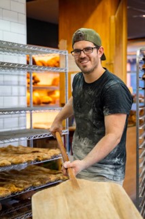 Portrait of baker of bakery in the workshop workshop of artisan bakery with the shovel of bread for
