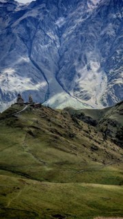 Panoramic view of Gergeti church and mountains, dominating natural scenery, Stepantsminda,