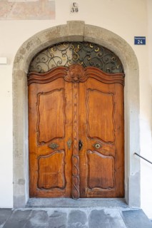 Artfully carved, baroque wooden door in a stone arched portal in the old town of Lindau, Bavaria,