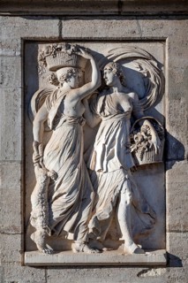 Antique relief on the obelisk fountain, market fountain, woman carrying food and drink, created in
