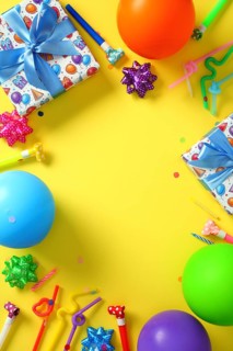 Flat lay, top view of colorful birthday party background with balloons and gifts on yellow