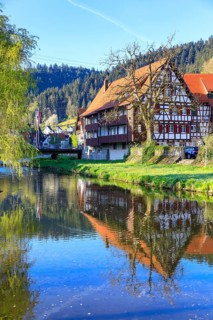 Tributary of the Schiltach into the Kinzig with reflection of historic half-timbered houses of the