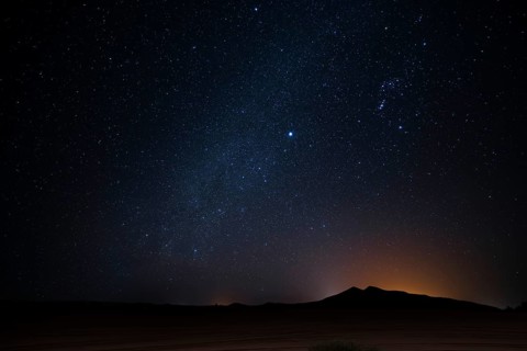 A breathtaking view of a star filled night sky over a Merzouga desert landscape, in Morocco. The
