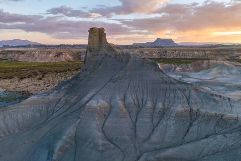 A breathtaking view of layered rock formations under a colorful sunset sky in Utah, capturing the