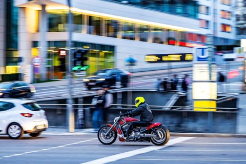 Motorbike in the evening in front of an urban environment with modern architecture, pull along.