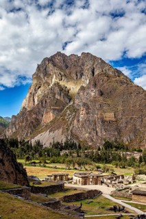Large mountain with ruins in the foreground, clouds and sun mingle, The Inca ruins of Ollantaytambo