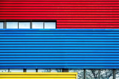 A striking image showcasing the facades of a colorful urban building in vivid red, blue, and