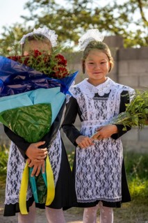 Schoolgirl with a bouquet of flowers on her first day at school, Issyk-Kul region, Kyrgyzstan