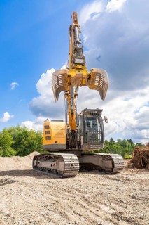 Yellow excavator on a construction site in sunny weather and cloudy sky, Demolition construction