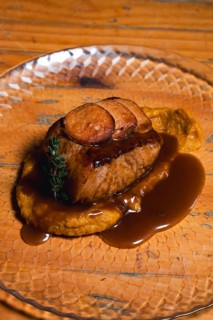 Indulge in a perfectly cooked beef tenderloin atop creamy mashed potatoes, drizzled with a