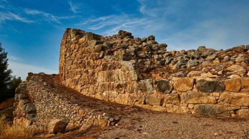 Cyclopean wall, ancient stone ruins with winding path and blue sky in the background, Tiryns,
