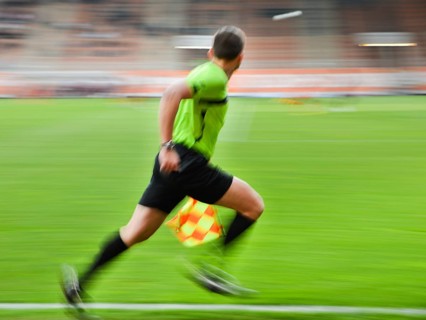 Sideline football referee runs during the match. Panning technic, in Lubin, Poland