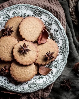 An artistic presentation of spiced cookies garnished with star anise, served on an intricately