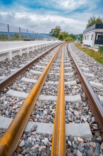 Tracks run through a landscape with buildings in the background, the atmosphere is calm and cloudy,