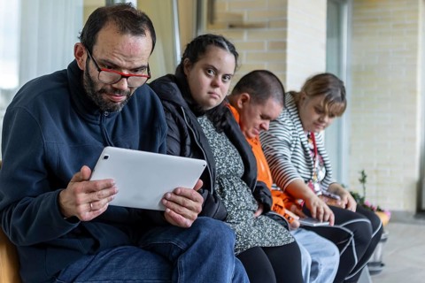 Individuals in a mental health residence engage with technology and connect with each other. The