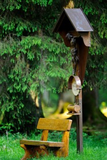 Crucifix next to a wooden bench in the forest, a place of contemplation, Bavaria