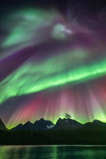 Northern lights over Bergen in the Lyngen Alps, reflection on the lake, Troms og Finnmark, Norway