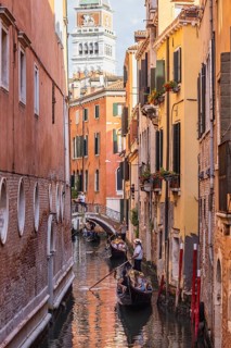 Venetian gondola with gondolier travelling on the canals of Venice, Venice, Italy
