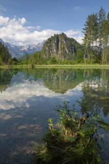 Lake Almsee in summer with totally smooth surface showing reflexion of the mountain Ameisstein