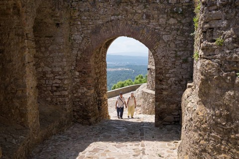 A senior couple enjoys a leisurely walk through a charming historic white village in Southern