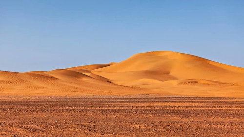Soft orange sand dunes against the clear blue desert sky, The sand dunes of the Sahara in Algeria