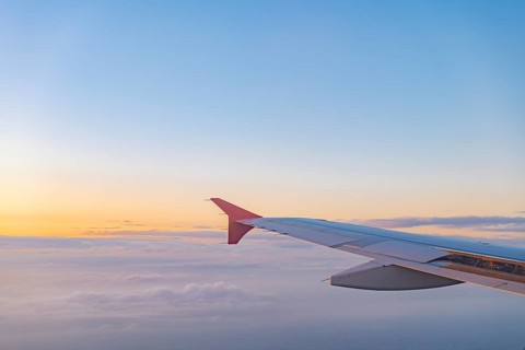 A stunning view from an airplane window capturing the wing against a colorful sunset sky, with
