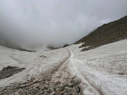 Mountain trail through snowy landscape under foggy sky, Rysy, High Tatras, Slovakia