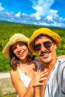 Tourists taking selfie with tropical forest in background during summer vacation in philippines