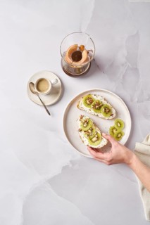 Gourmet kiwi toast garnished with creamy cheese, crunchy walnuts, and chia seeds. A delicious and