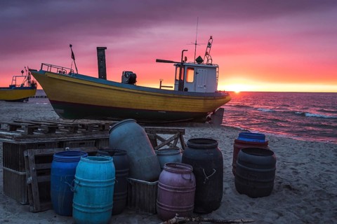 Fishing boat on the beach at sunset. Baltic sea