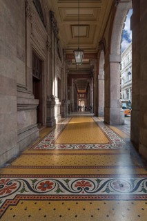 Arcaded walkway with mosaic floor from Palazzo della Borsa, built between 1907 and 1912, in Piazza