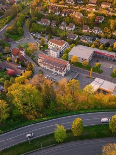 Aerial view of a residential area with streets and trees in autumnal colours at sunset, Nagold,