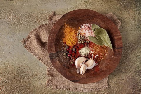 Spice mix, garlic and bay leaf, on a wooden plate, close-up, food concept, no people