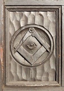 Historic carved masonic symbols on wooden panel on door of house in Marlborough, Wiltshire,
