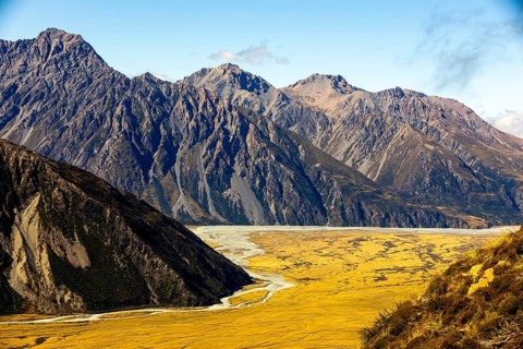 Golden hues of autumn at Mount Cook, New Zealand, where towering peaks meet vast plains. A beauty