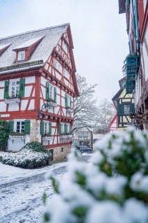 Snow-covered street with half-timbered houses in an idyllic winter landscape, Sindelfingen, Germany