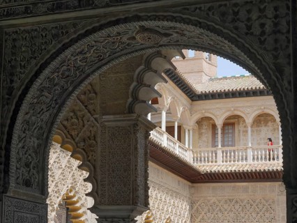 Real Alcazar, decorated arch overlooking ornate courtyard architecture and historic details,